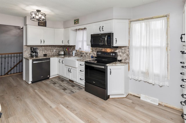 kitchen featuring light stone countertops, tasteful backsplash, sink, black appliances, and white cabinets