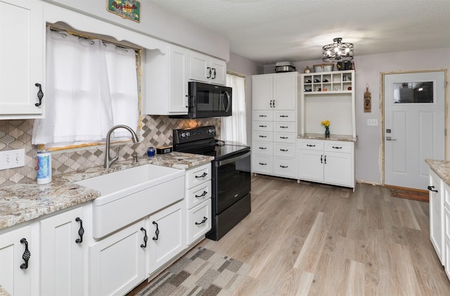 kitchen featuring sink, white cabinets, and black appliances