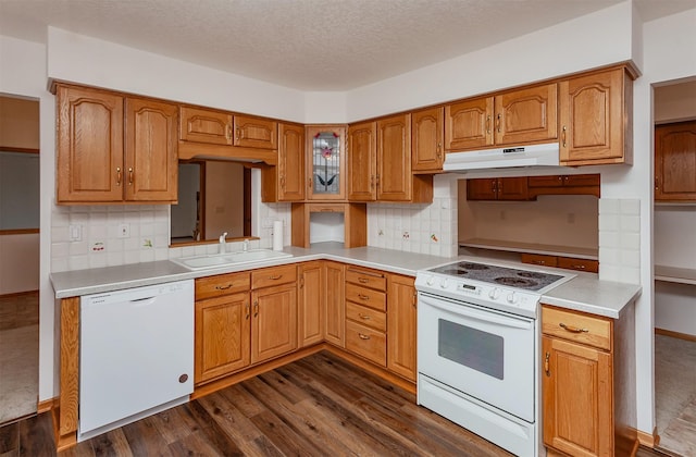 kitchen featuring white appliances, light countertops, a sink, and under cabinet range hood