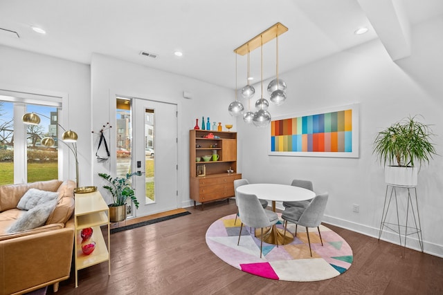 dining room with dark hardwood / wood-style floors and a healthy amount of sunlight