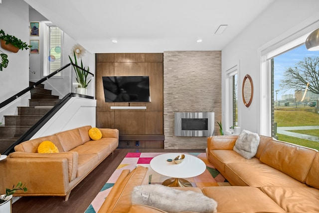 living room featuring a fireplace, dark hardwood / wood-style flooring, and heating unit