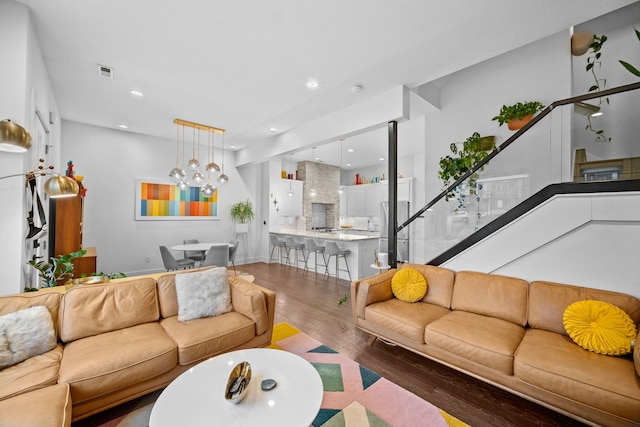 living room featuring wood-type flooring and an inviting chandelier