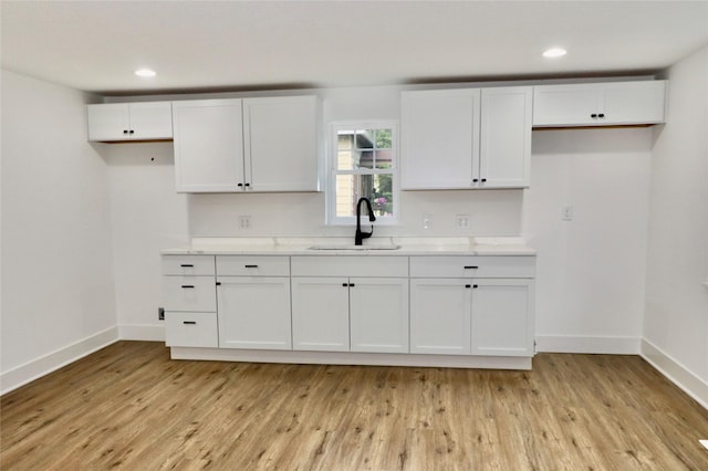 kitchen with sink, white cabinets, and light hardwood / wood-style floors