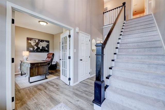 staircase featuring hardwood / wood-style flooring and french doors