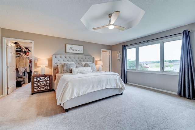 bedroom featuring ceiling fan, a walk in closet, carpet, and a closet