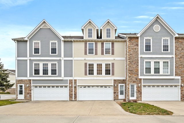 townhome / multi-family property featuring driveway and a garage