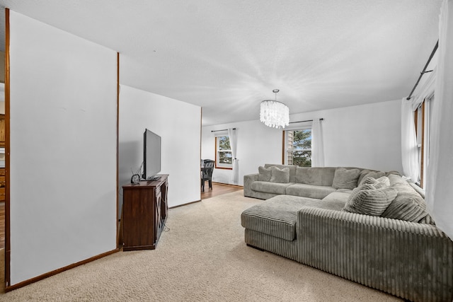 carpeted living room featuring an inviting chandelier