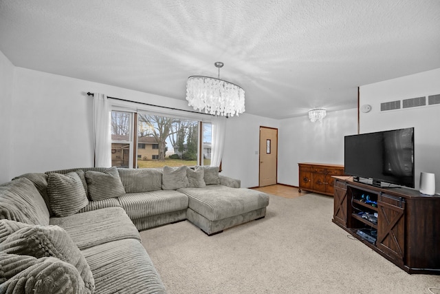 carpeted living room featuring a chandelier and a textured ceiling