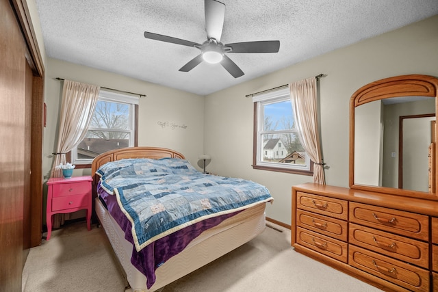 carpeted bedroom featuring ceiling fan, a closet, and a textured ceiling