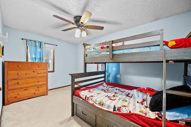 bedroom featuring light carpet, a textured ceiling, and ceiling fan