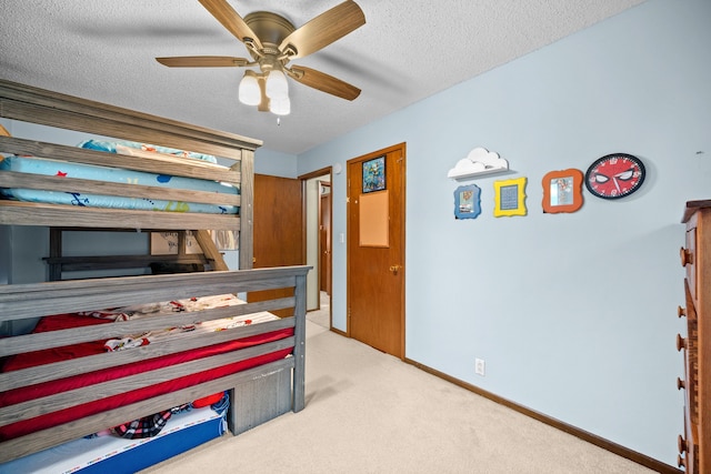 carpeted bedroom featuring ceiling fan and a textured ceiling