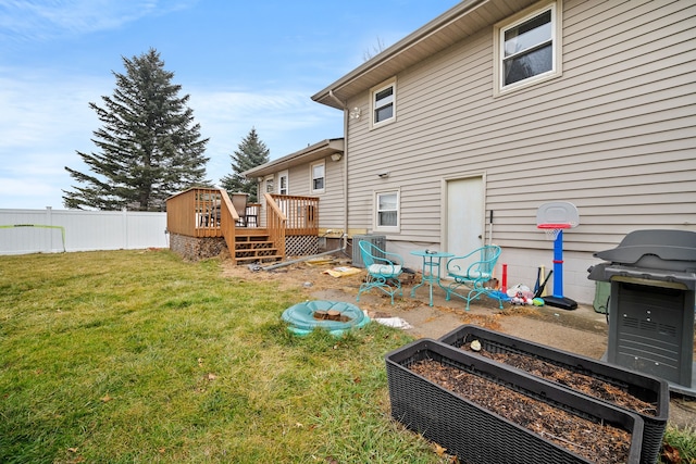 rear view of house with a lawn and a deck