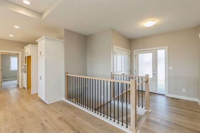 hallway featuring light hardwood / wood-style flooring and a healthy amount of sunlight