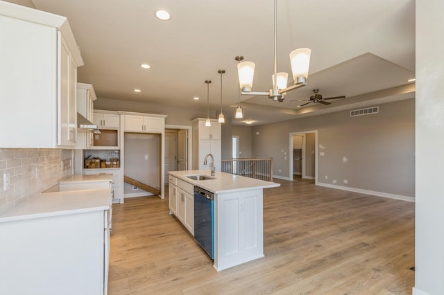 kitchen featuring sink, dishwasher, decorative light fixtures, a kitchen island with sink, and white cabinets