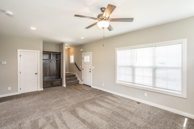 unfurnished living room with carpet and ceiling fan