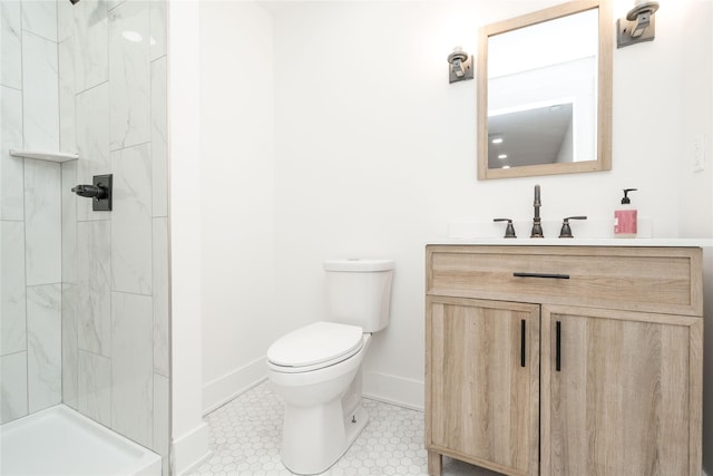 bathroom featuring a marble finish shower, toilet, vanity, and baseboards