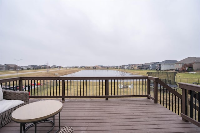 wooden terrace with a lawn, a water view, and a residential view