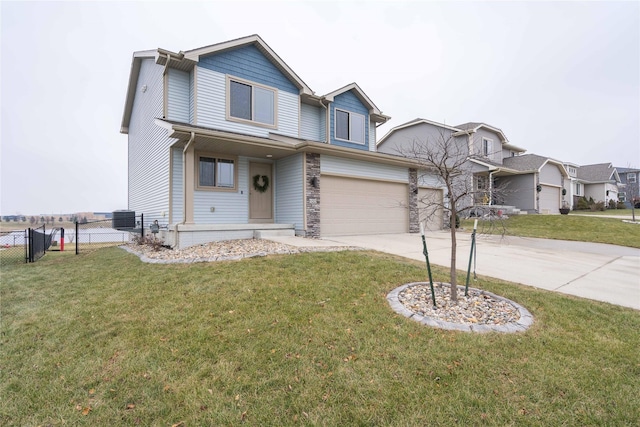 traditional-style house featuring a front yard, fence, driveway, an attached garage, and stone siding