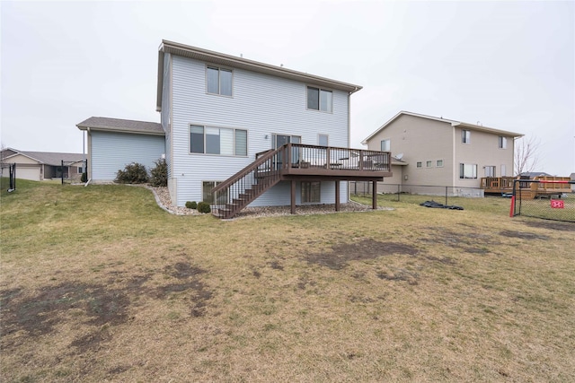 rear view of house with stairs, a deck, a yard, and fence