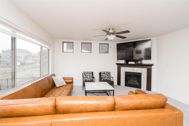 carpeted living area with baseboards, a ceiling fan, and a fireplace