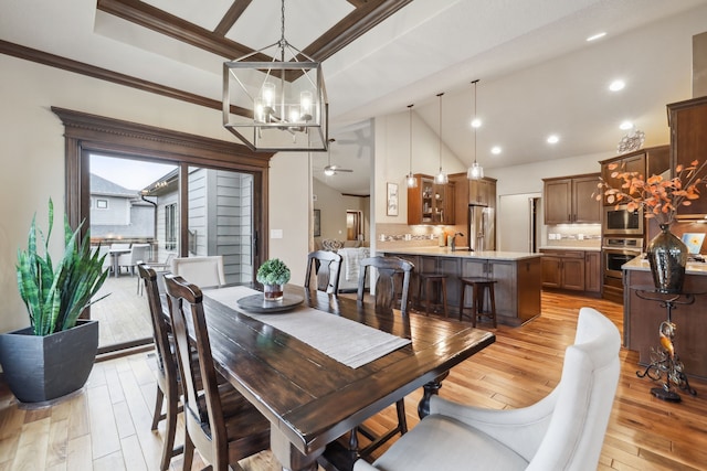 dining space with ceiling fan, sink, ornamental molding, and light wood-type flooring