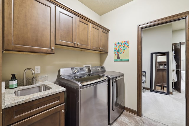 laundry room with cabinets, sink, light colored carpet, and washer and dryer