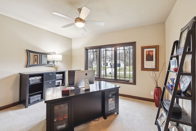 office space featuring light carpet, a textured ceiling, and ceiling fan