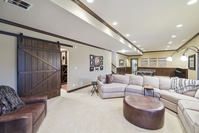 carpeted living room with a barn door and ornamental molding