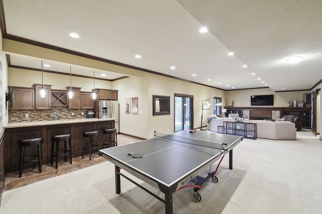 recreation room with light carpet, french doors, a textured ceiling, and ornamental molding