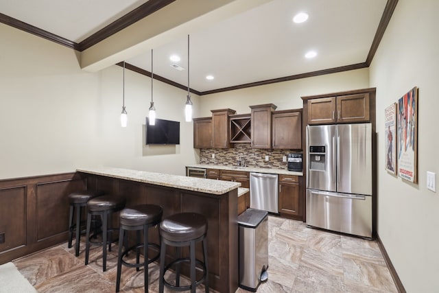 kitchen with pendant lighting, a breakfast bar area, decorative backsplash, kitchen peninsula, and stainless steel appliances