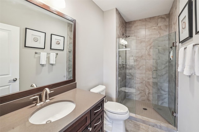 full bathroom with vanity, a shower stall, and toilet