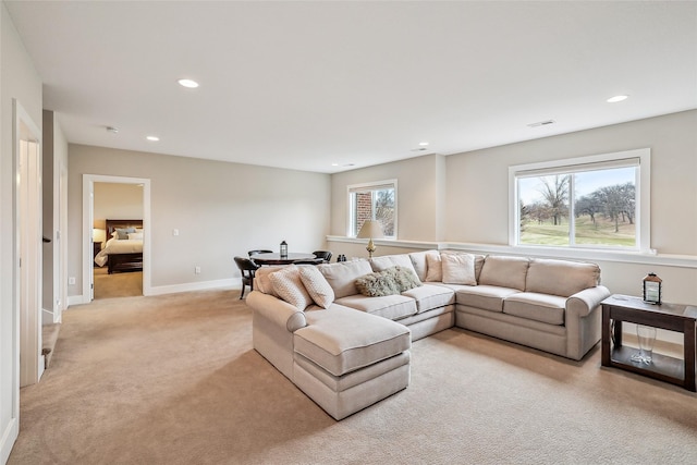 living area with baseboards, recessed lighting, visible vents, and light colored carpet