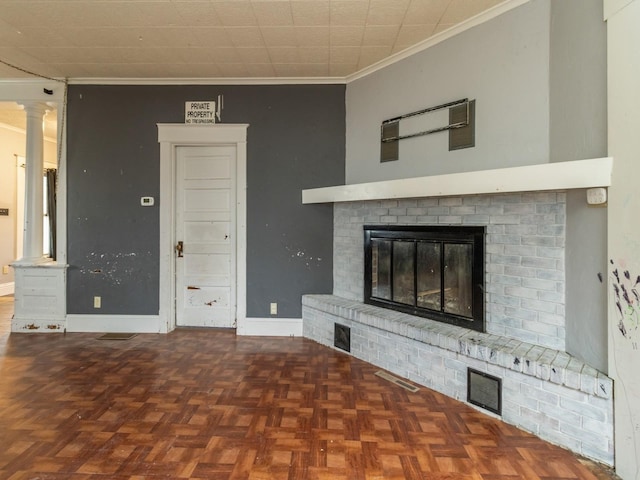 unfurnished living room with dark parquet floors, ornamental molding, and a fireplace