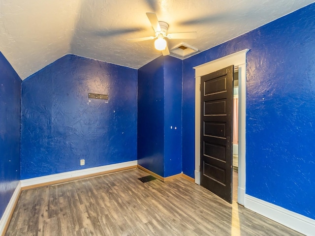 spare room featuring wood-type flooring, a textured ceiling, vaulted ceiling, and ceiling fan