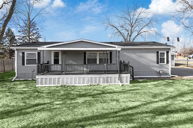 rear view of property featuring a yard and a porch