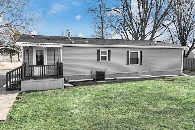 back of house with cooling unit and a yard