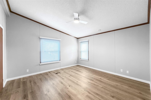 unfurnished room with a textured ceiling, ceiling fan, vaulted ceiling, hardwood / wood-style flooring, and crown molding