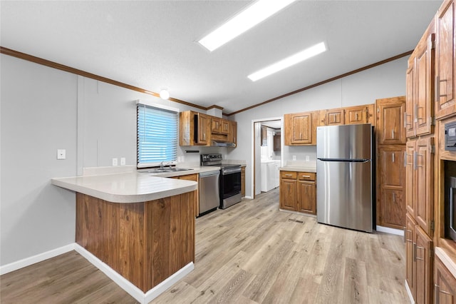 kitchen featuring washer and clothes dryer, light hardwood / wood-style flooring, kitchen peninsula, stainless steel appliances, and lofted ceiling