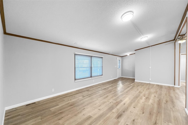 unfurnished room featuring light hardwood / wood-style flooring, a textured ceiling, and crown molding