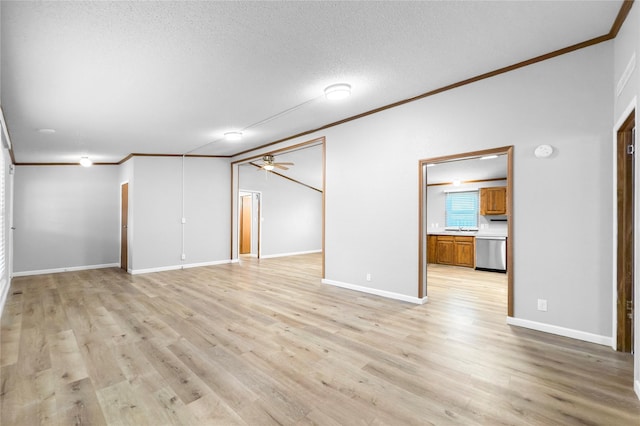 interior space with a textured ceiling, light wood-type flooring, ornamental molding, ceiling fan, and lofted ceiling