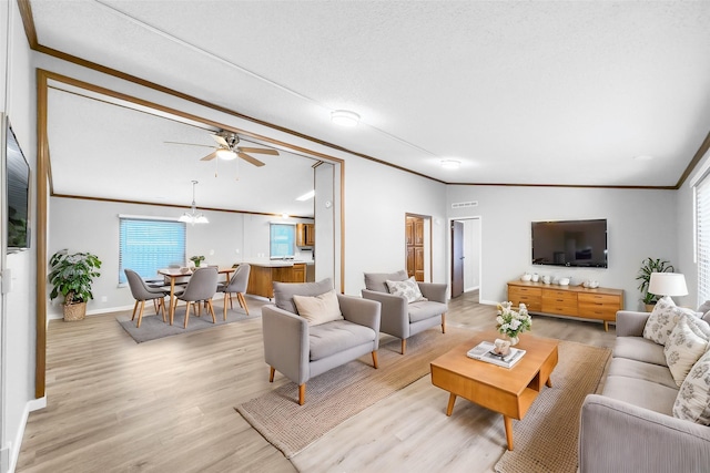 living room featuring ceiling fan with notable chandelier, ornamental molding, and light wood-type flooring