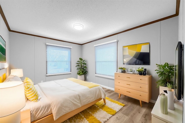 bedroom featuring hardwood / wood-style floors, crown molding, and a textured ceiling