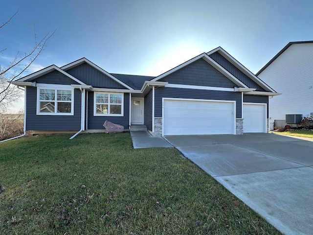 view of front of house featuring central air condition unit, a front yard, and a garage