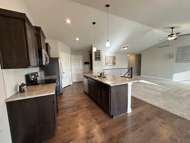 kitchen featuring an island with sink, lofted ceiling, decorative light fixtures, decorative backsplash, and appliances with stainless steel finishes