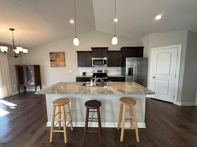 kitchen with a center island with sink, an inviting chandelier, appliances with stainless steel finishes, and tasteful backsplash