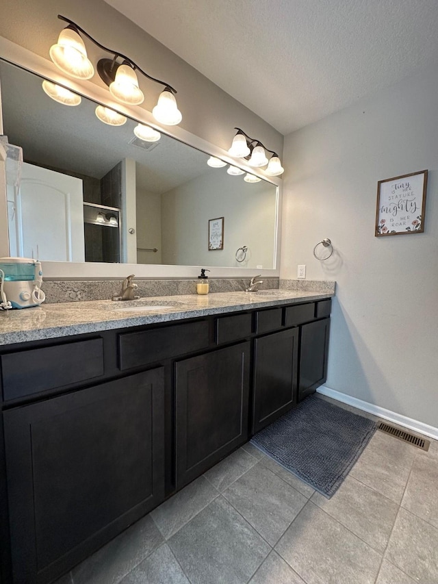 bathroom featuring vanity, a textured ceiling, and a shower with door