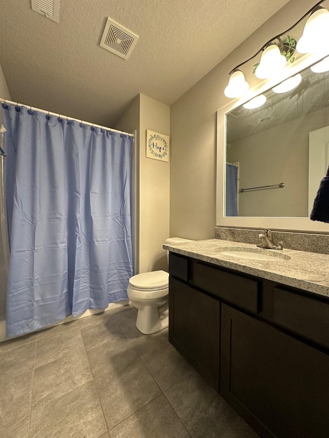 bathroom with vanity, a textured ceiling, and toilet