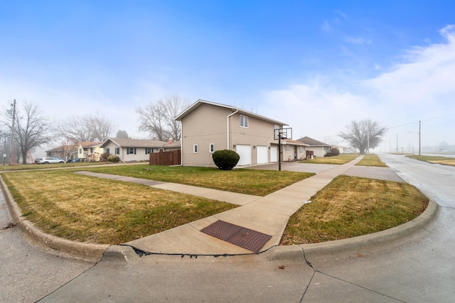 view of side of property featuring a garage and a yard