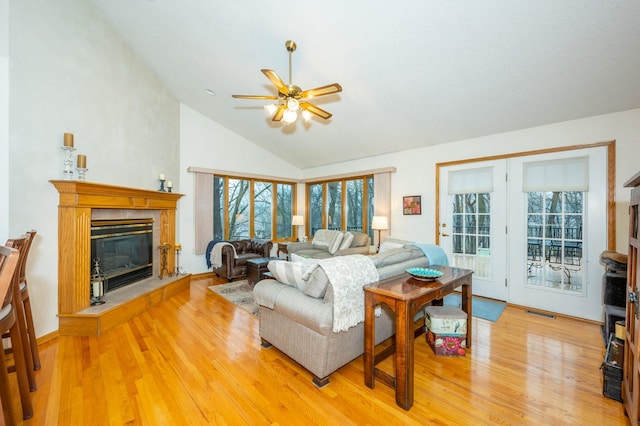 living room featuring ceiling fan, vaulted ceiling, and light hardwood / wood-style flooring