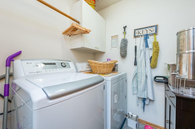 clothes washing area with cabinets and independent washer and dryer